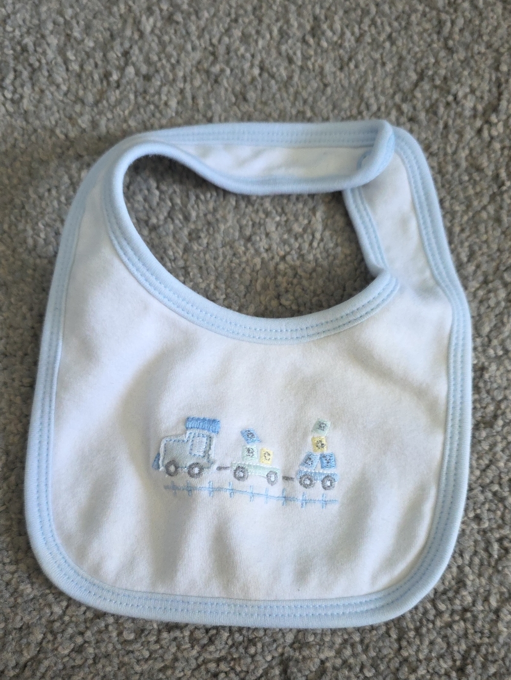 White Baby Bib with Light Blue Trim and Train Motif
